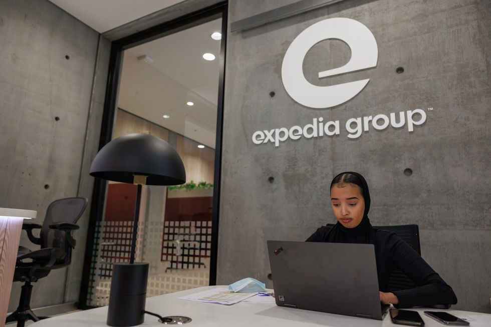 A female professional working on her computer in the Expedia Group office