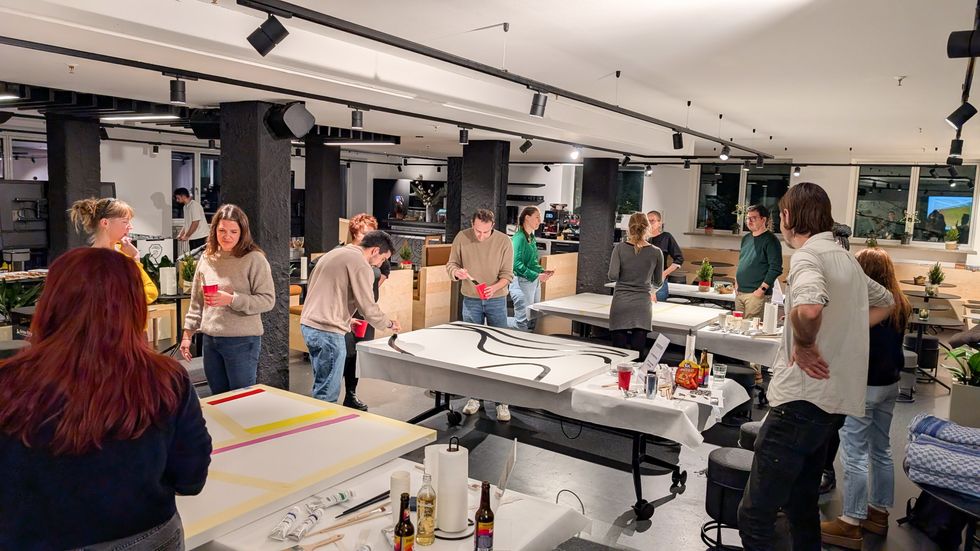 A group of Celonis employees painting canvases together at a team bonding event.