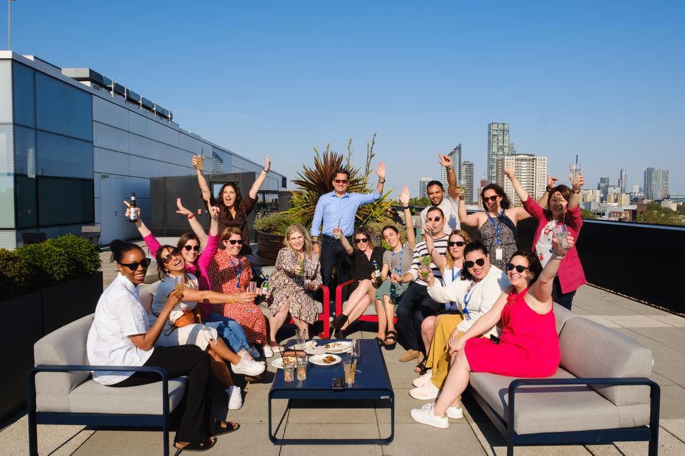 A group of Expedia Group employees on a rooftop posing for a photo