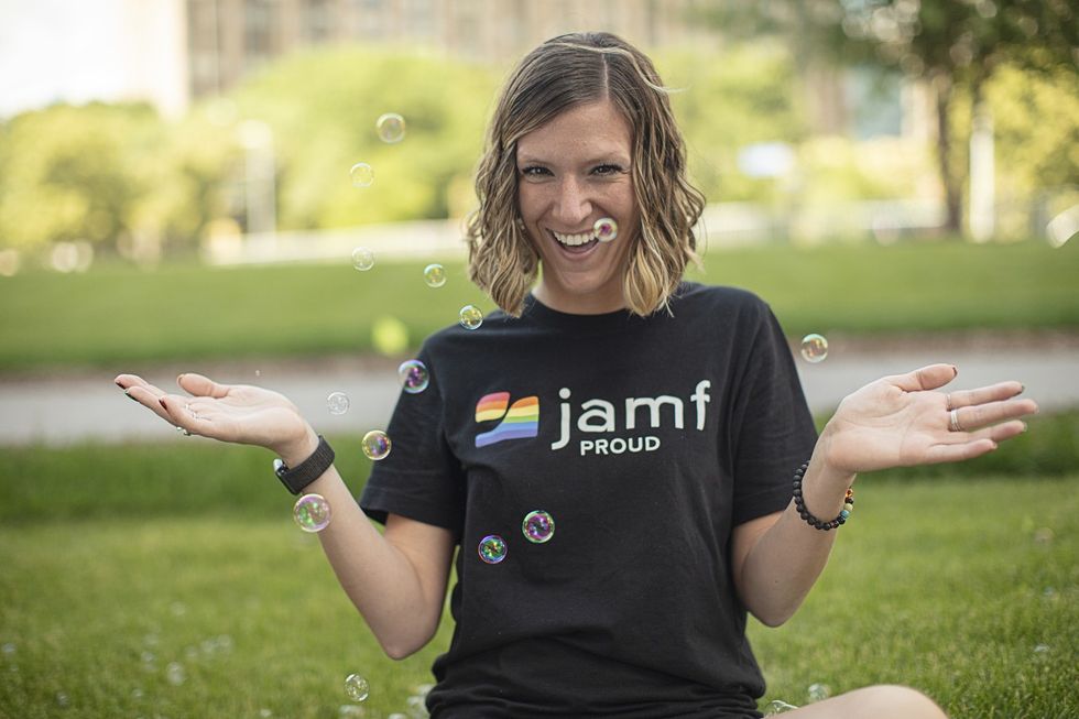 A Jamf employee wearing a shirt that says "Jamf proud" with Pride colors