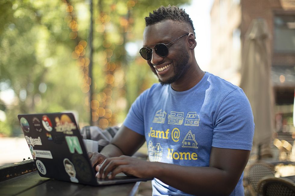 A man working on his computer from an outdoor patio