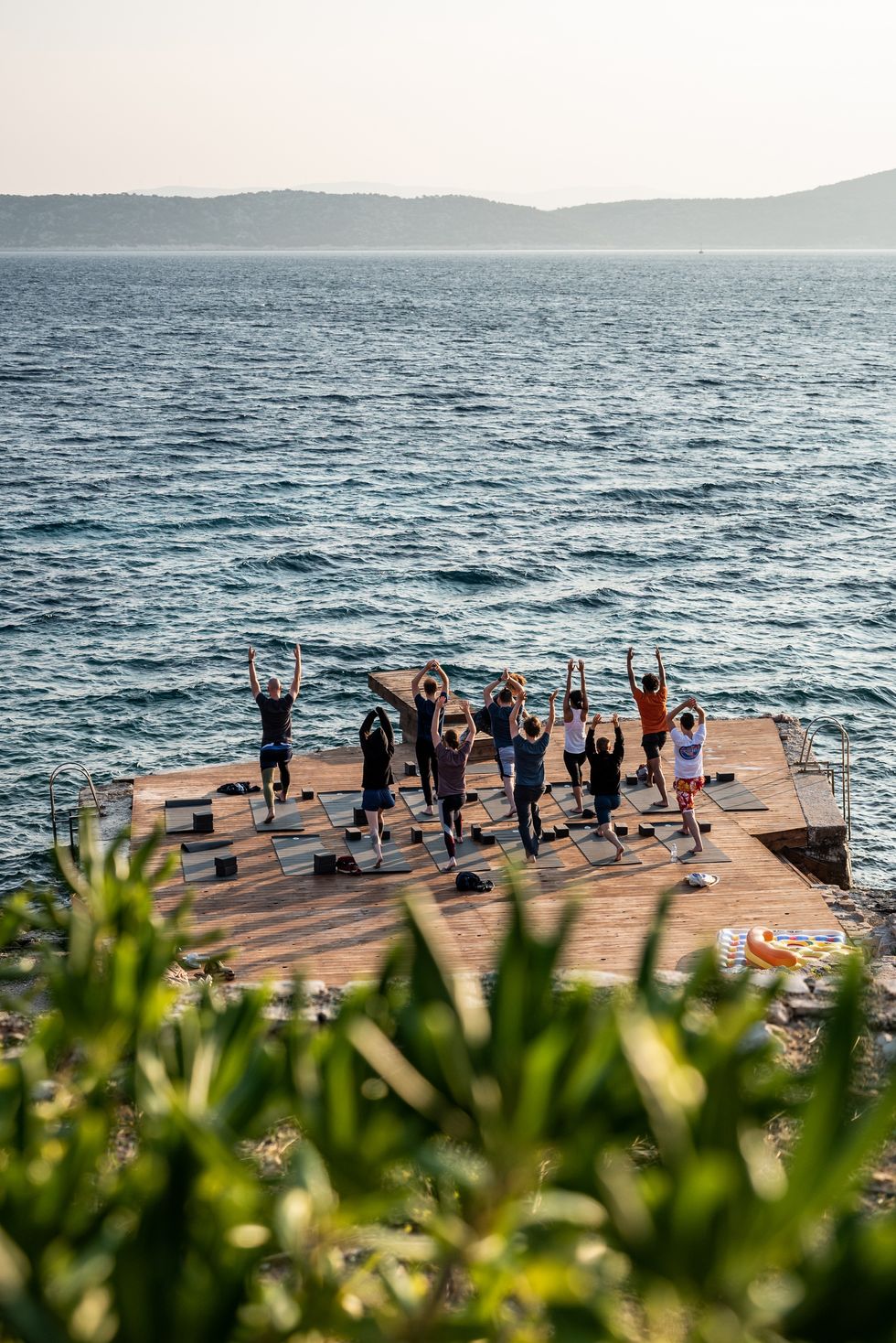 Camunda employees doing yoga on a dock by a lake