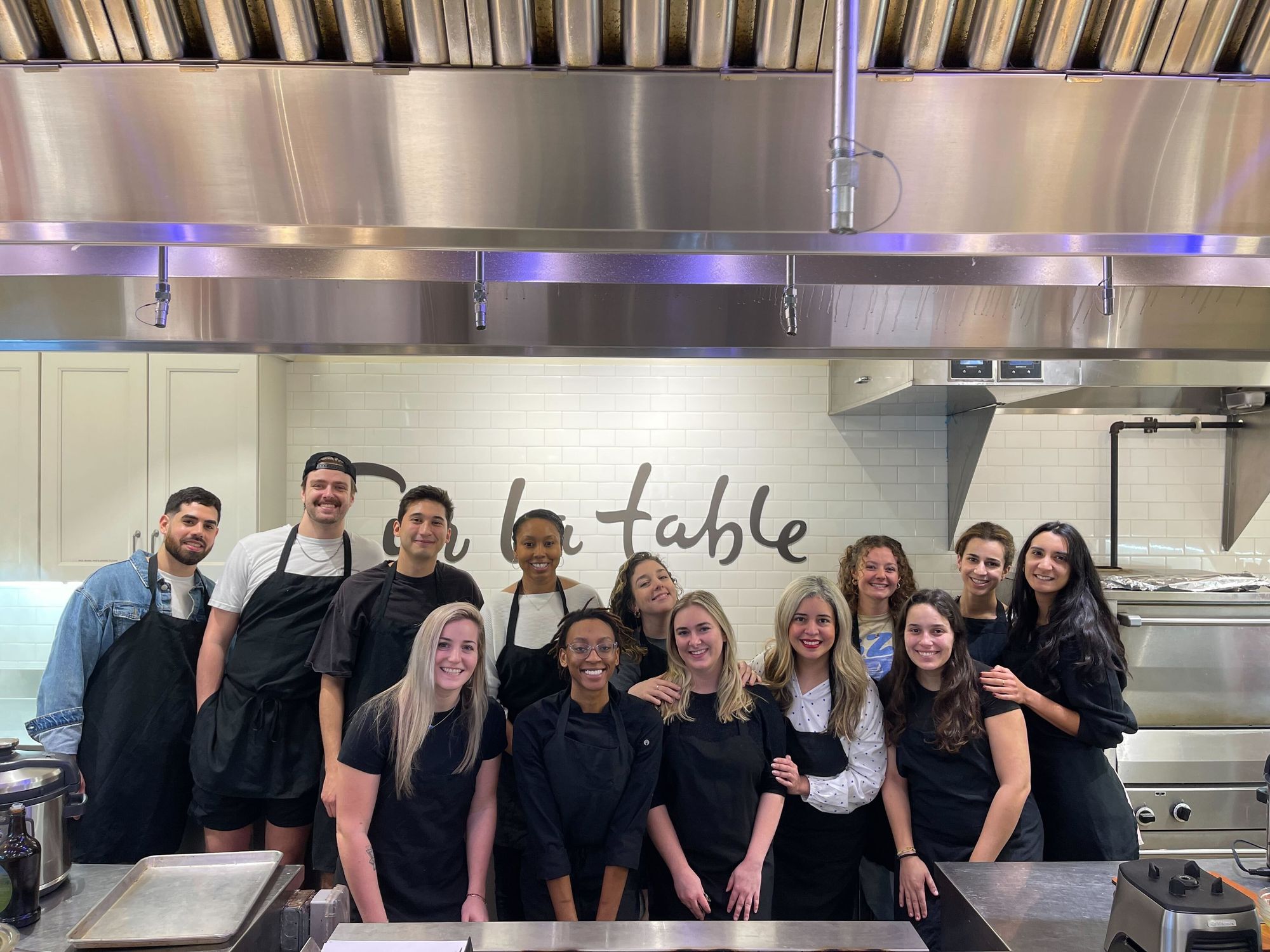 Celonis team members smiling for a photo in a kitchen