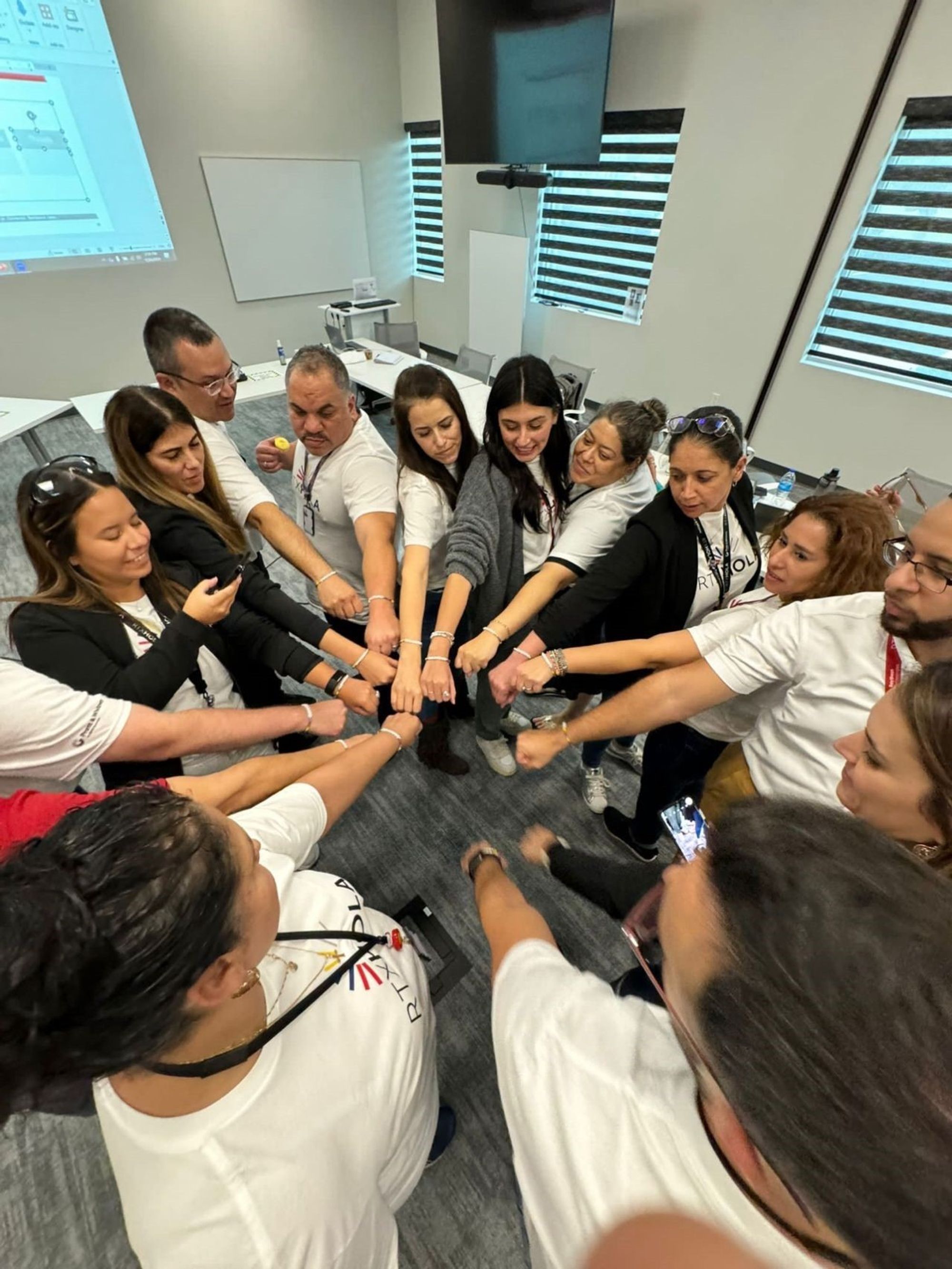 Collins Aerospace team members all putting their hands together in a huddle to represent team work or unison