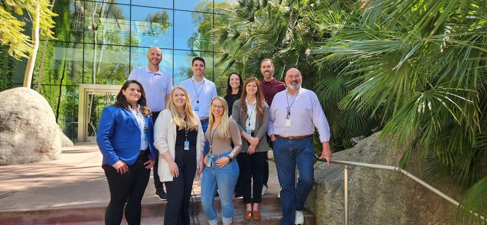 Esri employees posing for a photo in front of an office