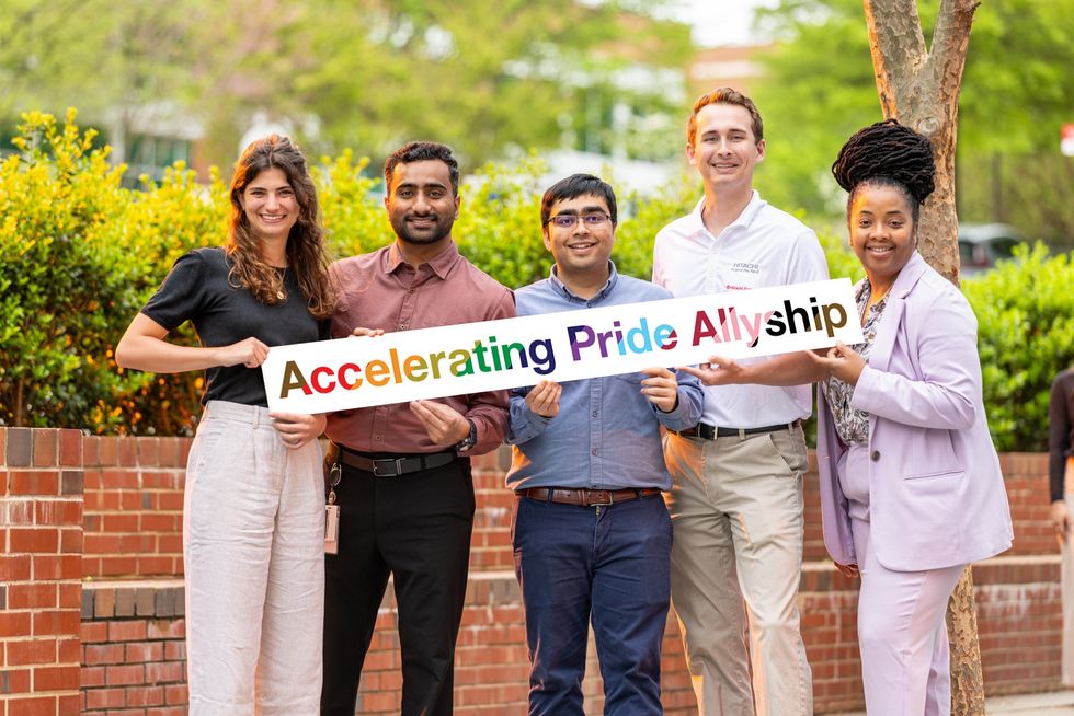 Five Hitachi employees holding sign that says: Accelerating Pride Allyship