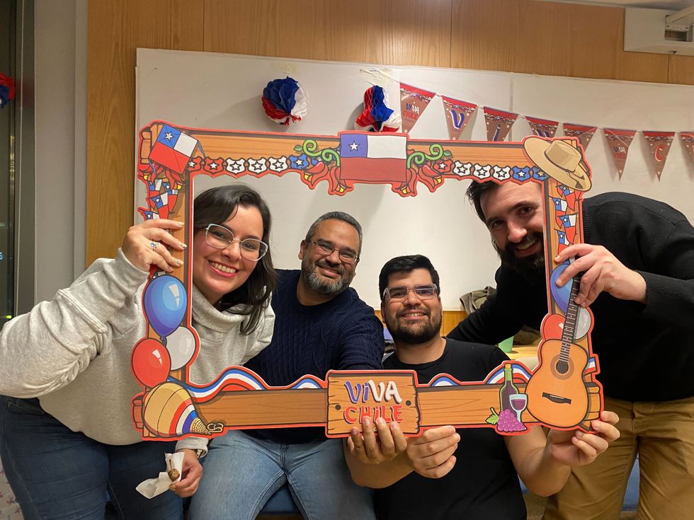 Four PagerDuty team members posing inside of a frame that says "Viva Chile." 