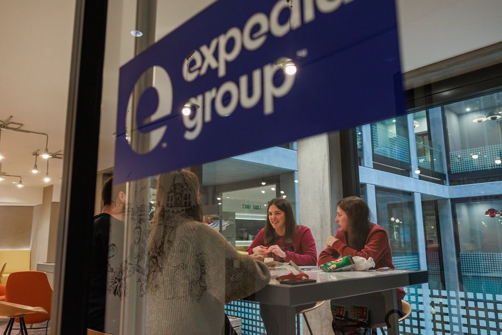 Four people sitting and eating at a table in an Expedia Group breakroom 