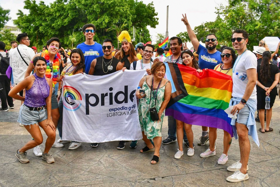 Group of Expedia Group employees posing with Pride flags