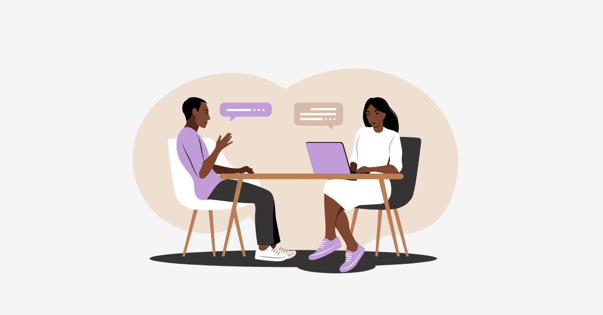 Illustration of wo people sitting in chairs at a table with laptop computers having a conversation.