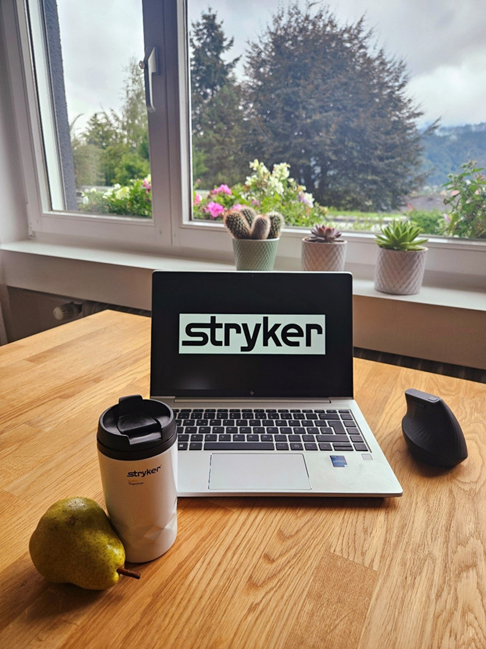 Laptop and coffee mug with Stryker logo
