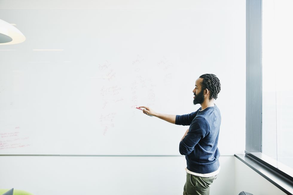 Man pointing at white board with marker