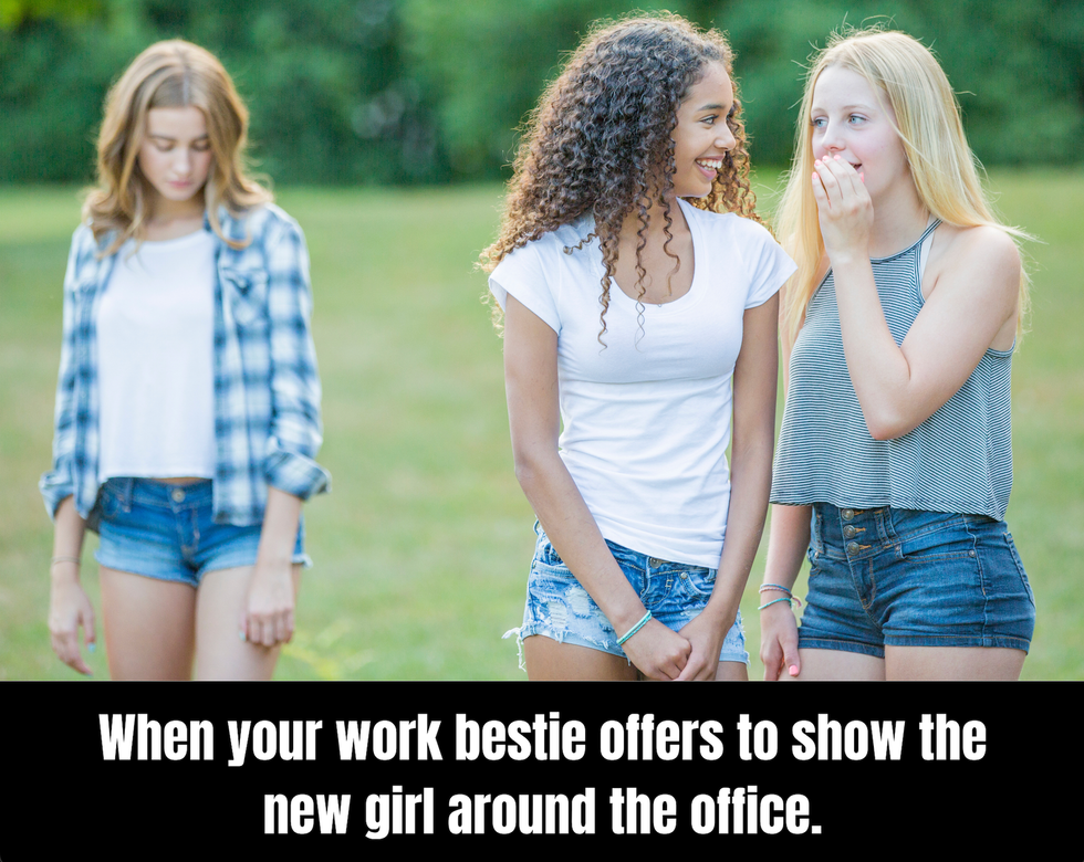 Meme showing two girls whispering to each other while one sadly sulks behind them. The text says: When your work bestie offers to show the new girl around the office.