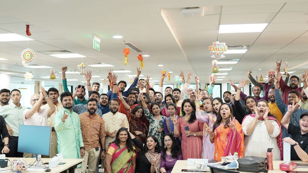 Okta team members wearing Indian attire and smiling for the camera 