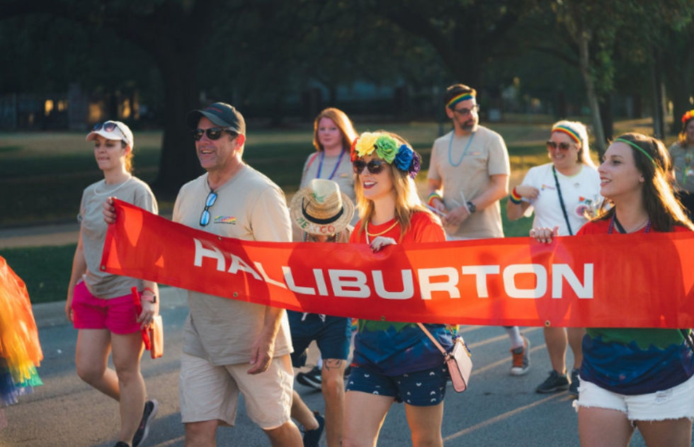 People marching with a banner that says Haliburton at a Pride parade