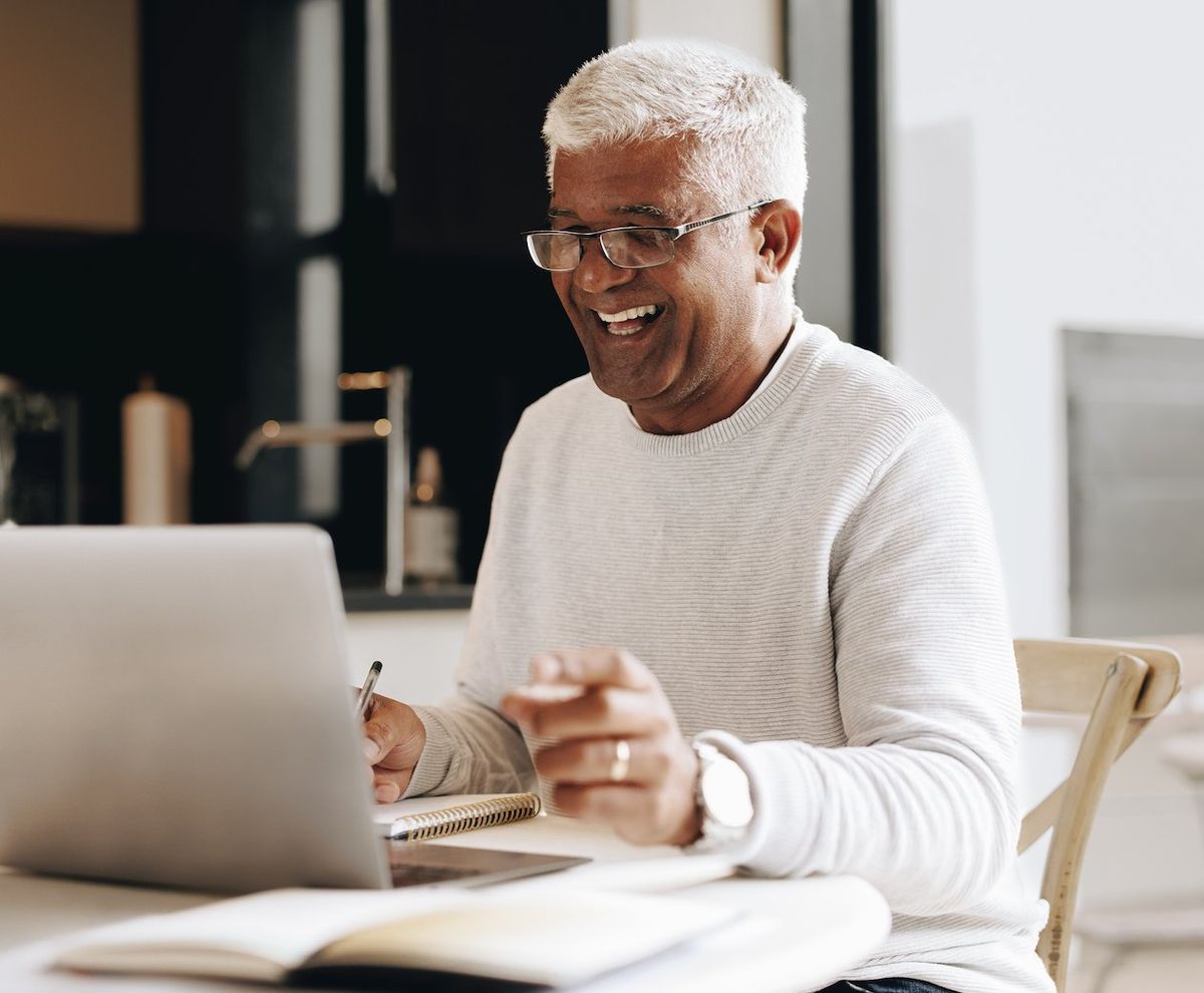 Photo of man talking into a laptop 