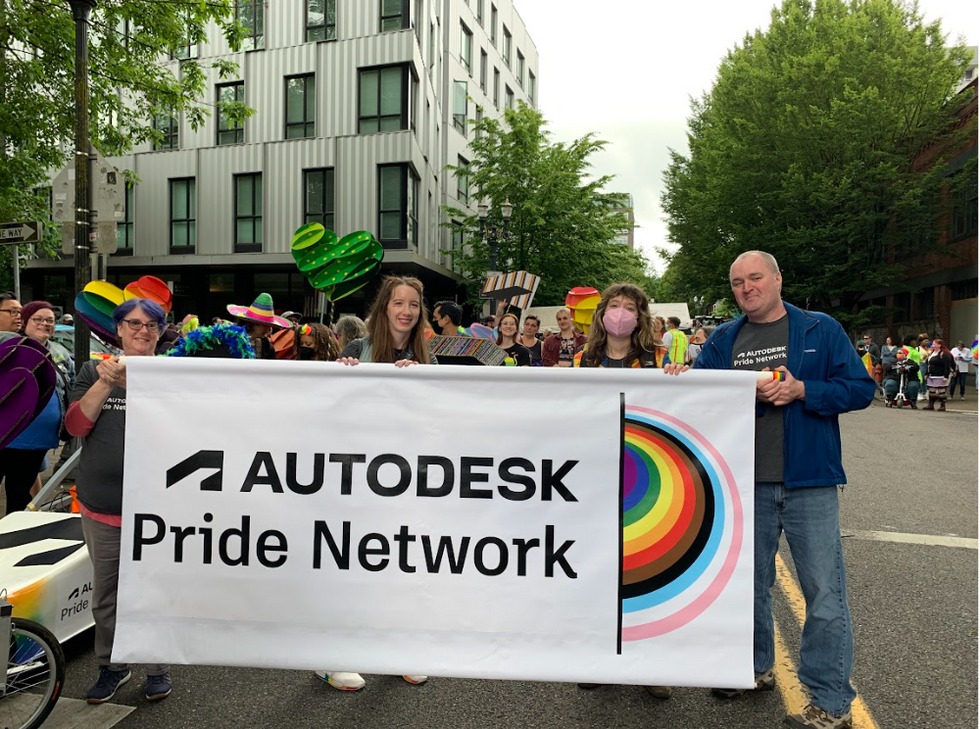 Photo of people at a Pride parade holding a sign that says Autodesk Pride Network