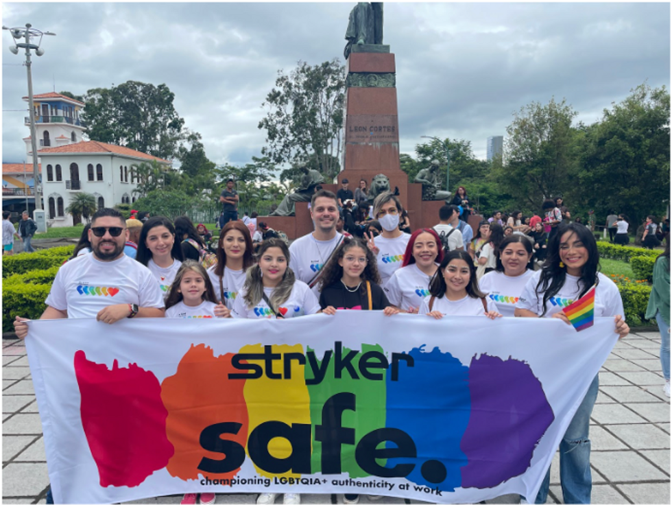 Stryker employees holding a sign that says Stryker safe. Championing LGBTQIA+ authenticity at work.