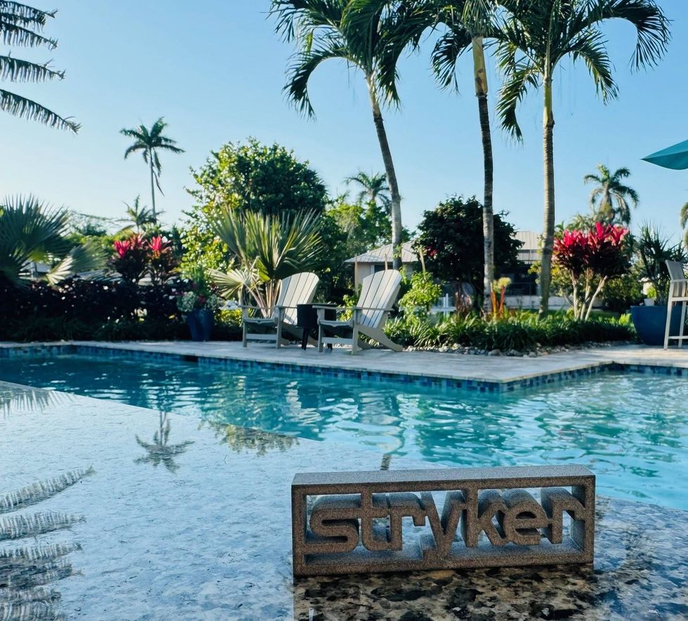 Stryker logo with a pool and beach chairs in the background