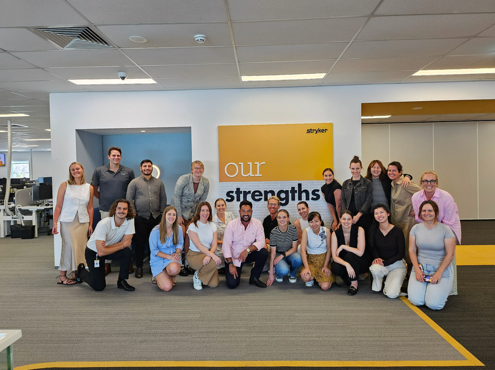 Stryker team members posing for a photo in their office