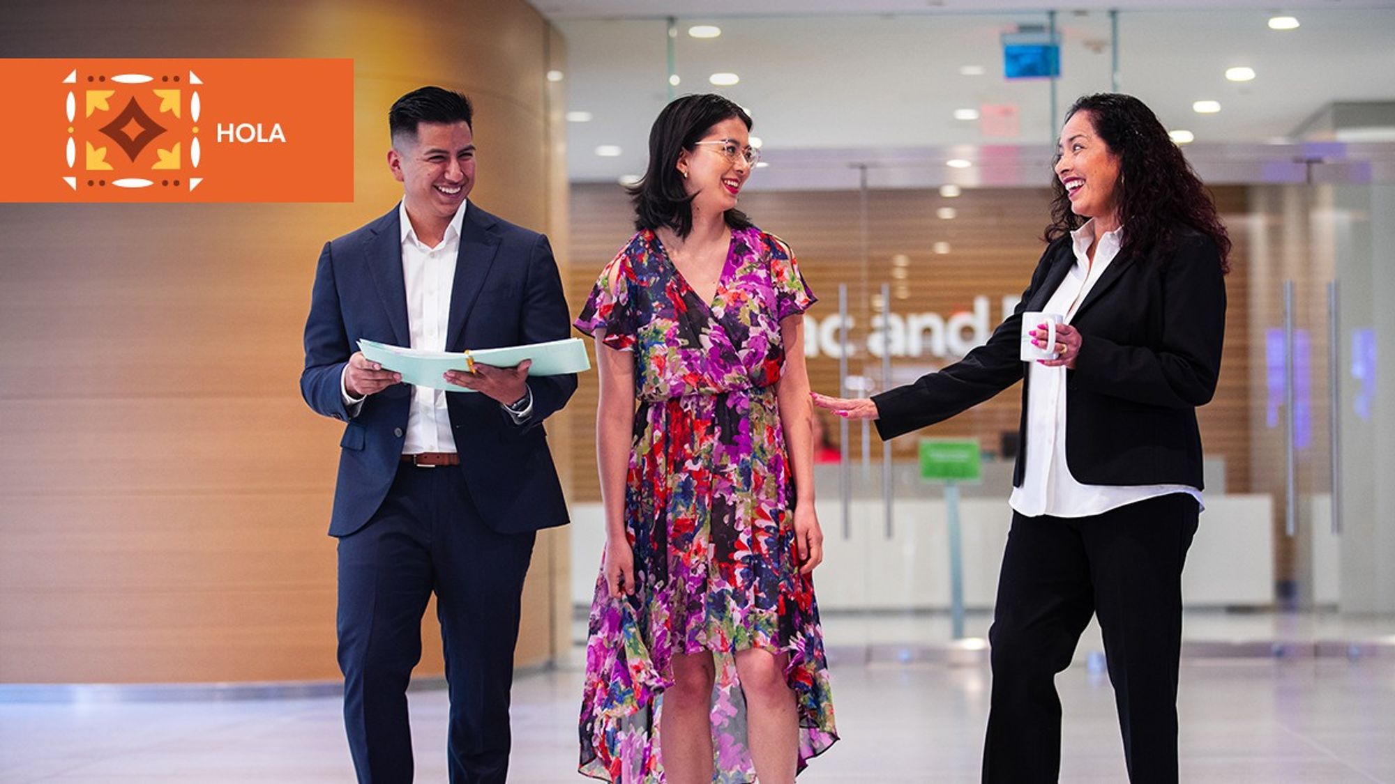 Three Freddie Mac team members, part of the HOLA employee resource group, smiling in their office 