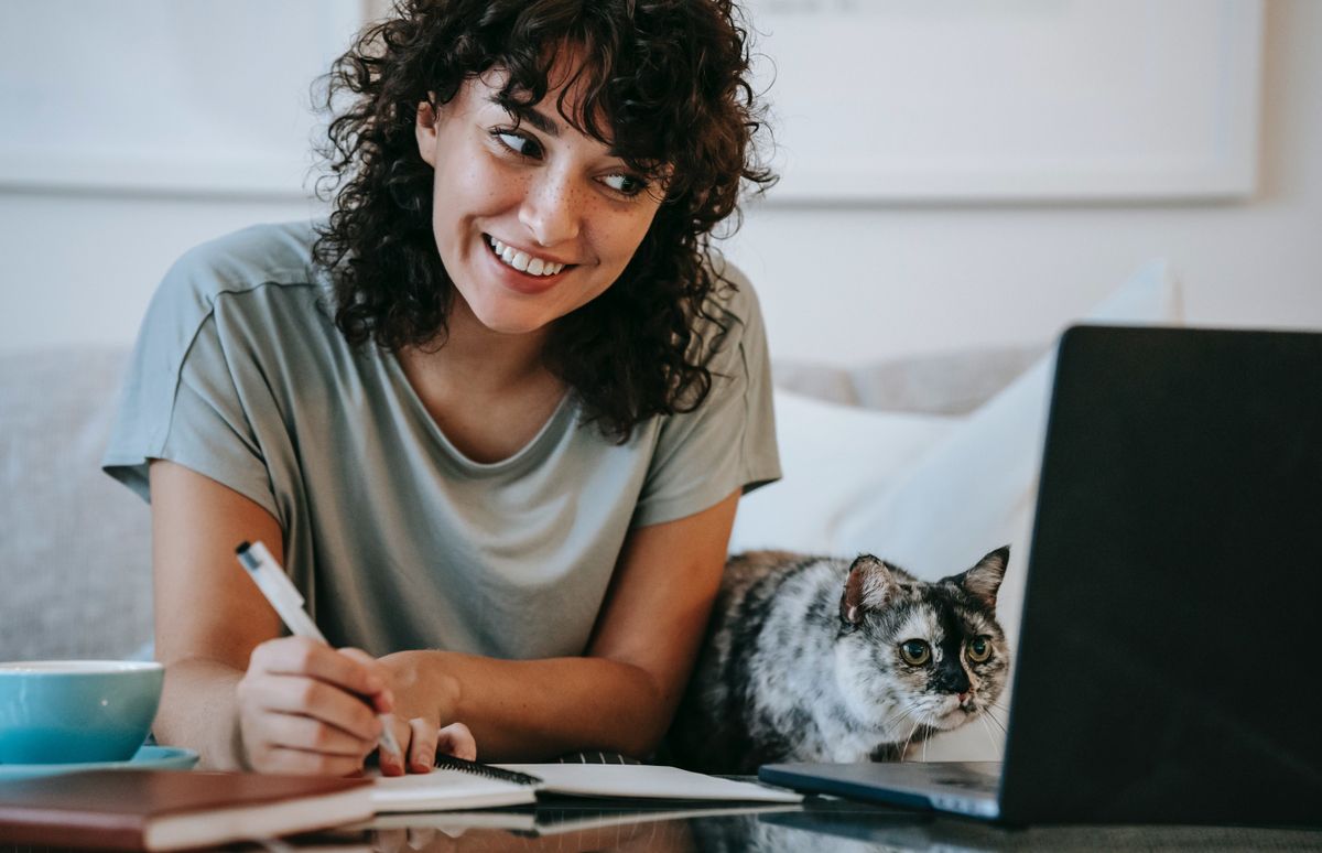 Woman at computer watching PowerToFly Videos with cat