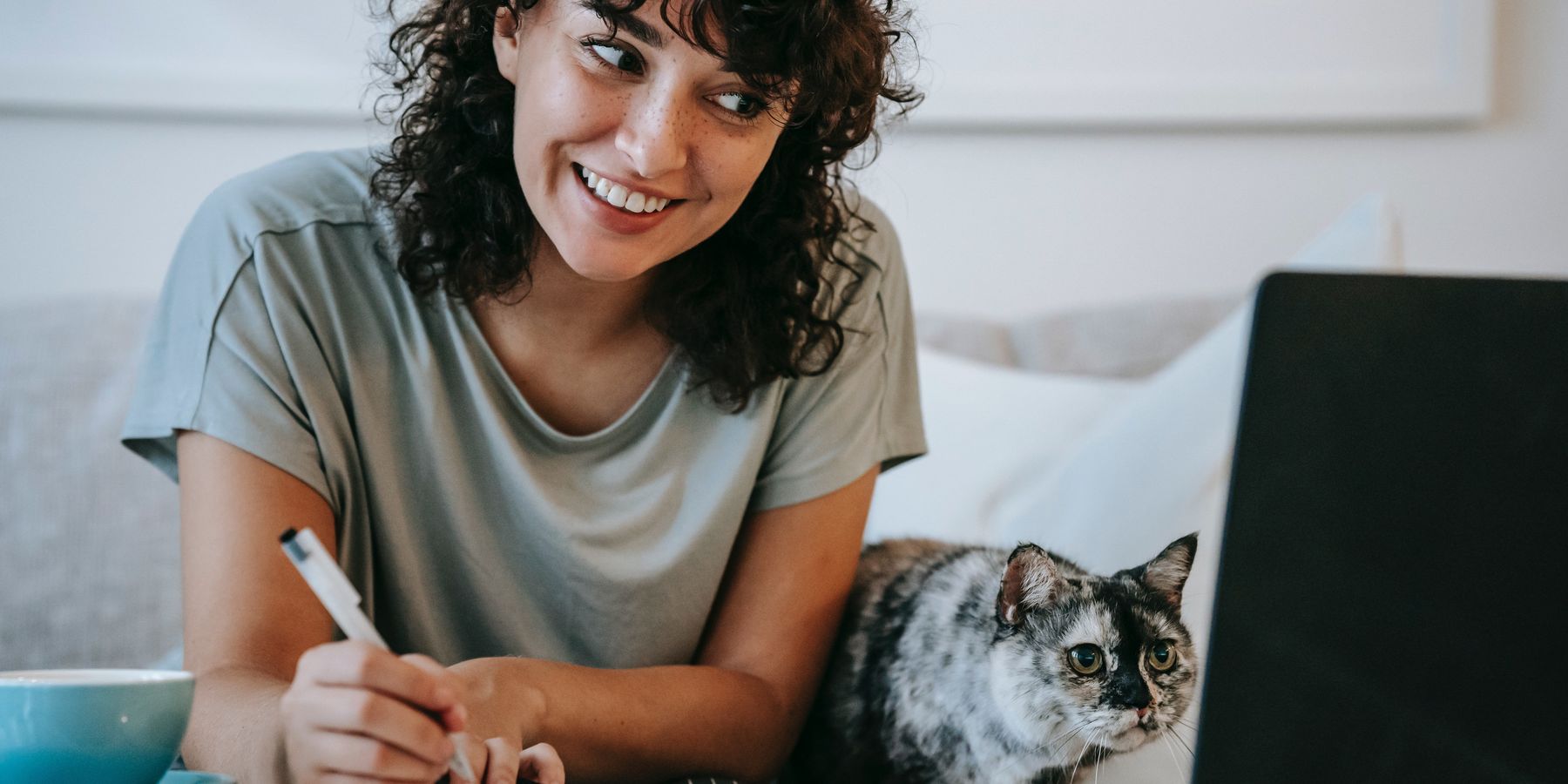 Woman at computer watching PowerToFly Videos with cat
