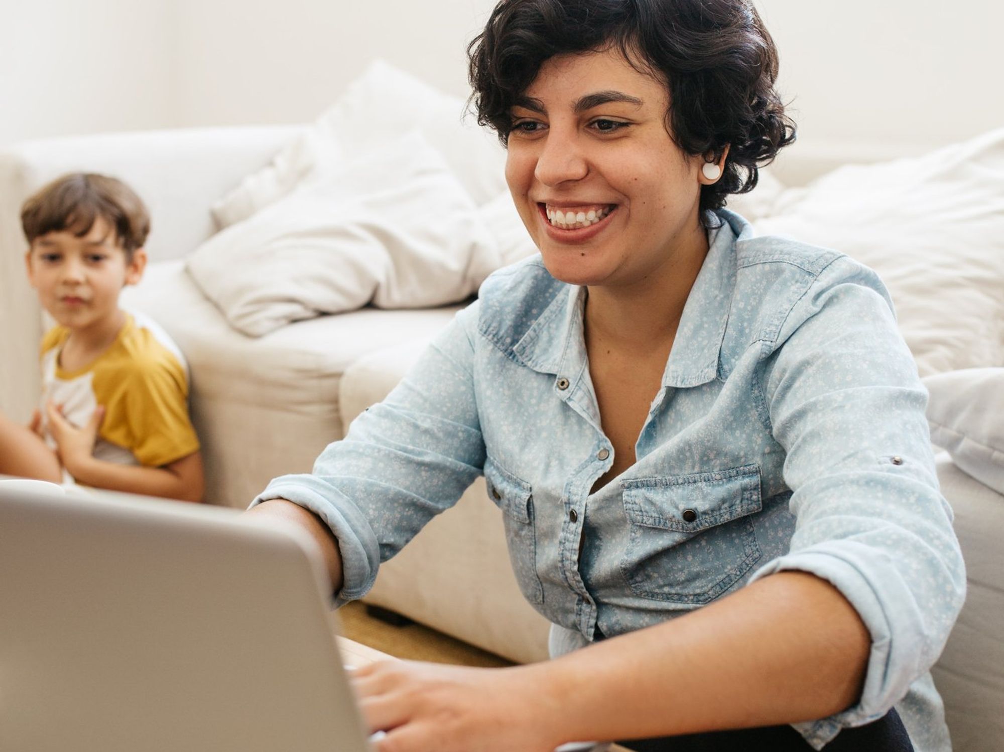 Woman smiling working remotely on a laptop
