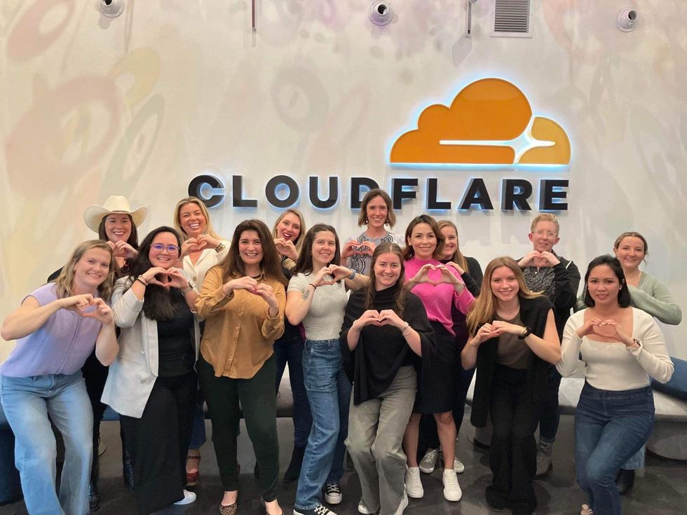 Women at Cloudflare posing for a photo, making a heart shape with their hands